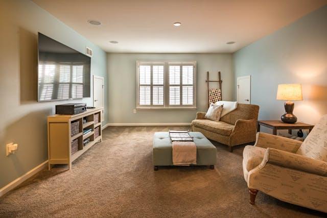 A clean, carpeted living room.
